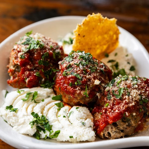 Cucina Pizza & Bar's Italian meatballs with red sauce, ricotta, parmesan, and parsley.
